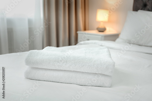 Stack of towels on bed in modern hotel room