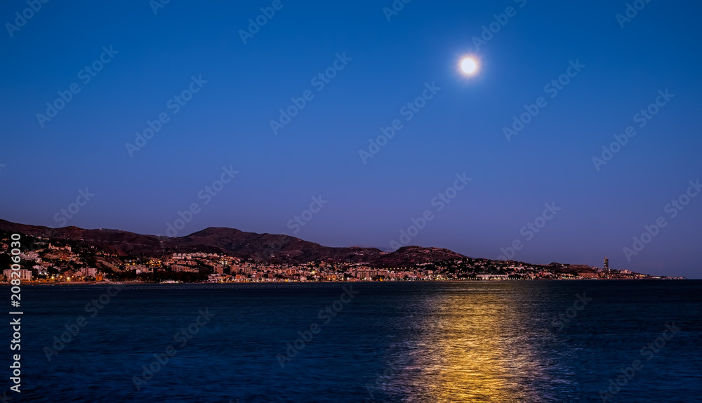 The moon over the sea and Malaga city, Spain