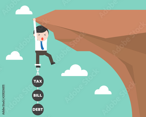 Businessman chained with iron ball hanging on cliff, burden from tax, bill and debt concept