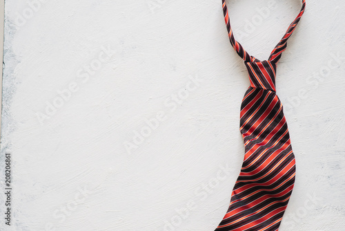 Happy Father's Day inscription with colorful tie on floor background.