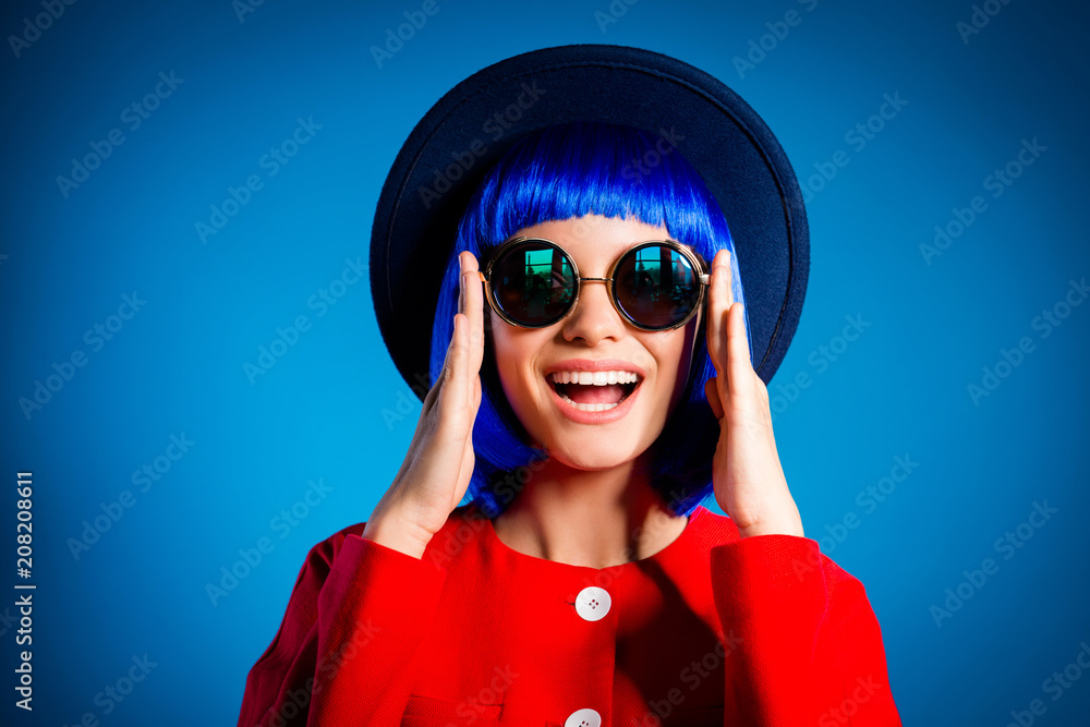 Head shot portrait of positive toothy girl with beaming smile laughing laud sincerely fixing correcting summer eyeglasses on face isolated on blue background Head shot portrait of positive toothy girl with beaming smile laughing laud sincerely fixing correcting summer eyeglasses on face isolated on blue background