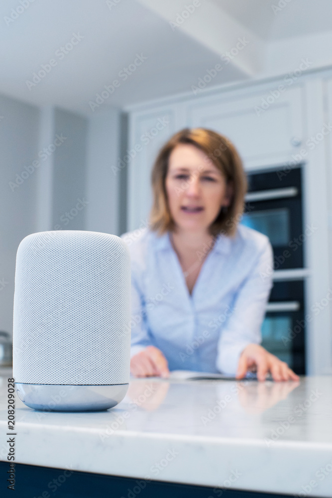 Woman In Kitchen Asking Digital Assistant Question Woman In Kitchen Asking Digital Assistant Question
