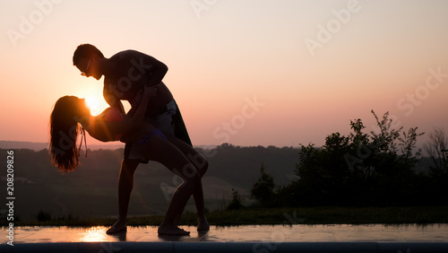 Fototapeta Naklejka Na Ścianę i Meble -  Romantic dance at sunset by couple