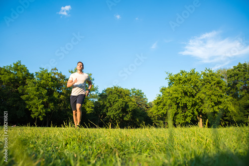 A handsome young man running during sunset in a park © Spectral-Design