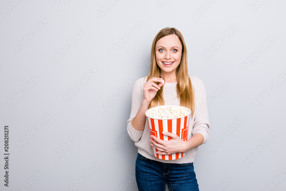 Portrait with copy space empty place of cheerful positive girl funny comic laughter having basket of sweet salt pop corn in hands enjoying favorite movie isolated on grey background Portrait with copy space empty place of cheerful positive girl funny comic laughter having basket of sweet salt pop corn in hands enjoying favorite movie isolated on grey background
