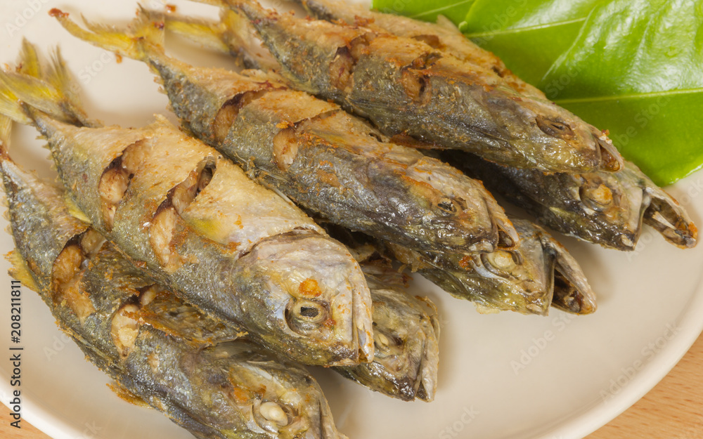 Mackerel fish fried in white dish.