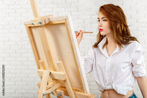 Beautiful young woman painter at work