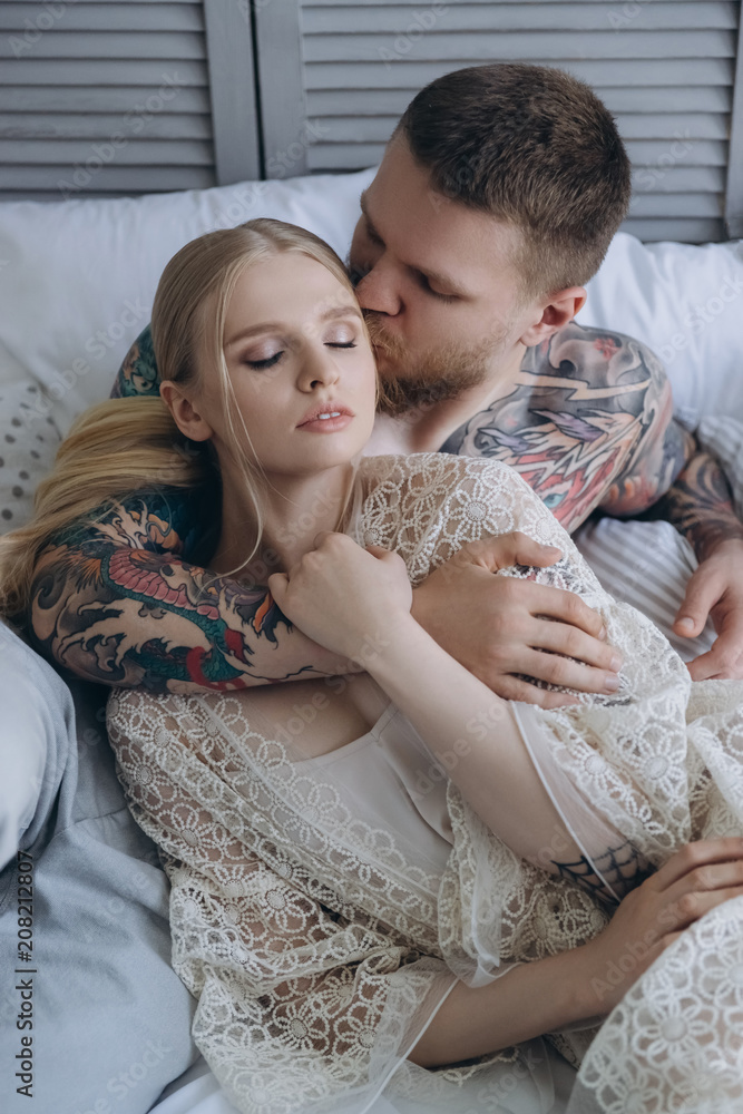 top view of handsome young man embracing her girlfriend from behind while lying in bed top view of handsome young man embracing her girlfriend from behind while lying in bed