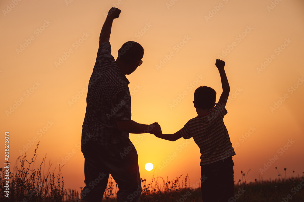 Father and son playing in the park at the sunset time. Father and son playing in the park at the sunset time.