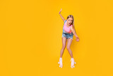 Portrait of nervous depressed girl learning roller skating carefully keeping balance trying not to fall down screaming loud isolated on yellow background
