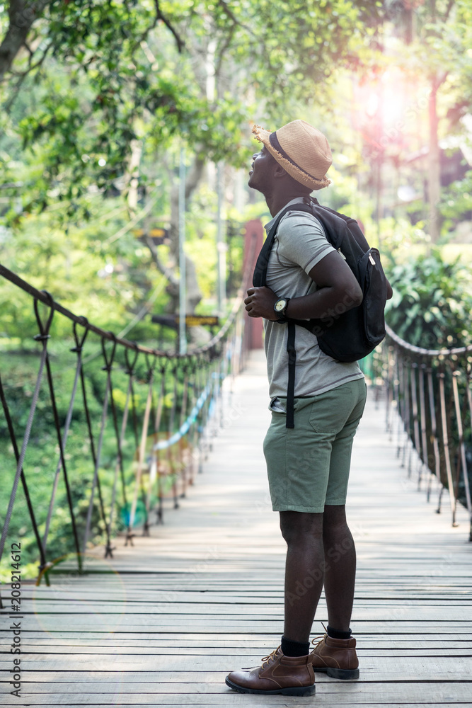 African man traveller with backpack standing on the bridge. African man traveller with backpack standing on the bridge.