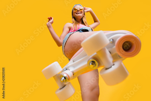 Fotografia Bottom view of roller skate step on camera, cheerful joyful playful funky girl s