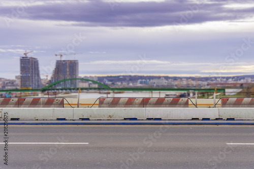 City bridge empty asphalt road with city and river and dramatic sky in the background © bennian_1