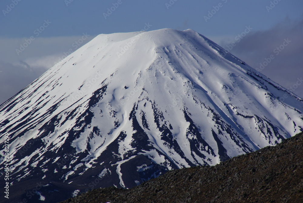 Snowy volcano mountains among clouds aerial view