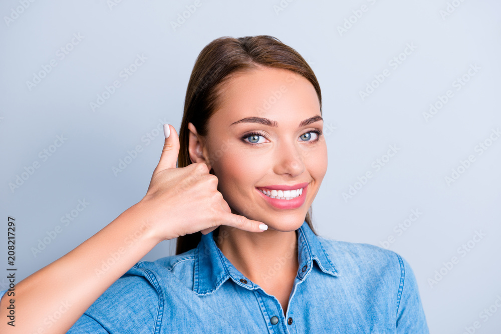 Call me baby! Portrait of friendly cute girl showing telephone symbol with fingers near face isolated on grey background Call me baby! Portrait of friendly cute girl showing telephone symbol with fingers near face isolated on grey background