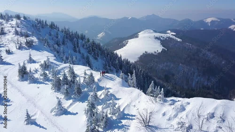 Aerial shot of mountains covered in snow in winter on sunny day Aerial shot of mountains covered in snow in winter on sunny day