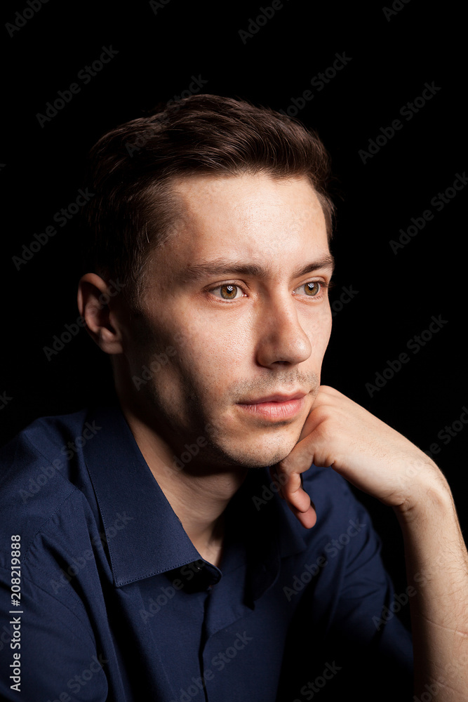 Fototapeta premium Portrait with fashion lighting of young man on black background