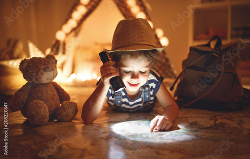 funny child girl tourist with flashlight and world map and backpack
