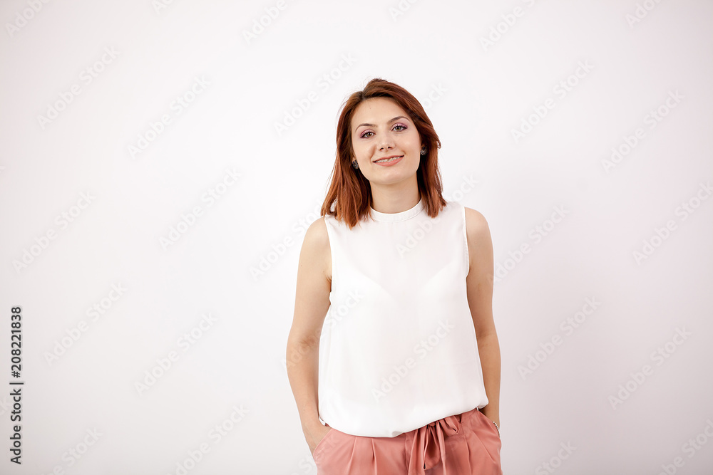 Portrait of smiling young woman on white wall. Studio photo Portrait of smiling young woman on white wall. Studio photo