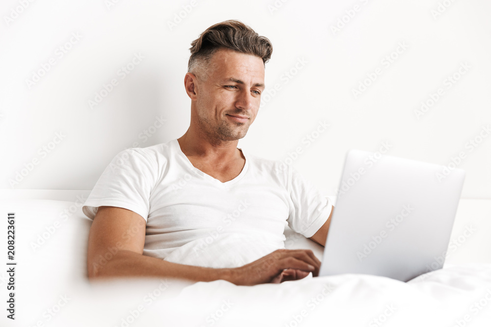 Smiling man using laptop computer Smiling man using laptop computer