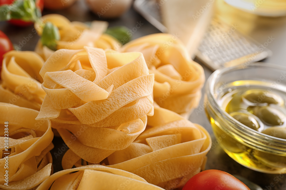 Uncooked fettuccine pasta and products on table