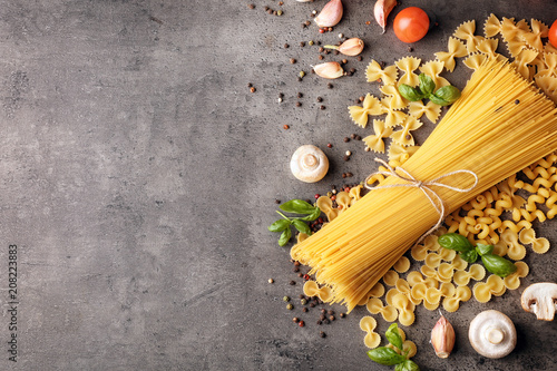 Uncooked pasta and products on grey background