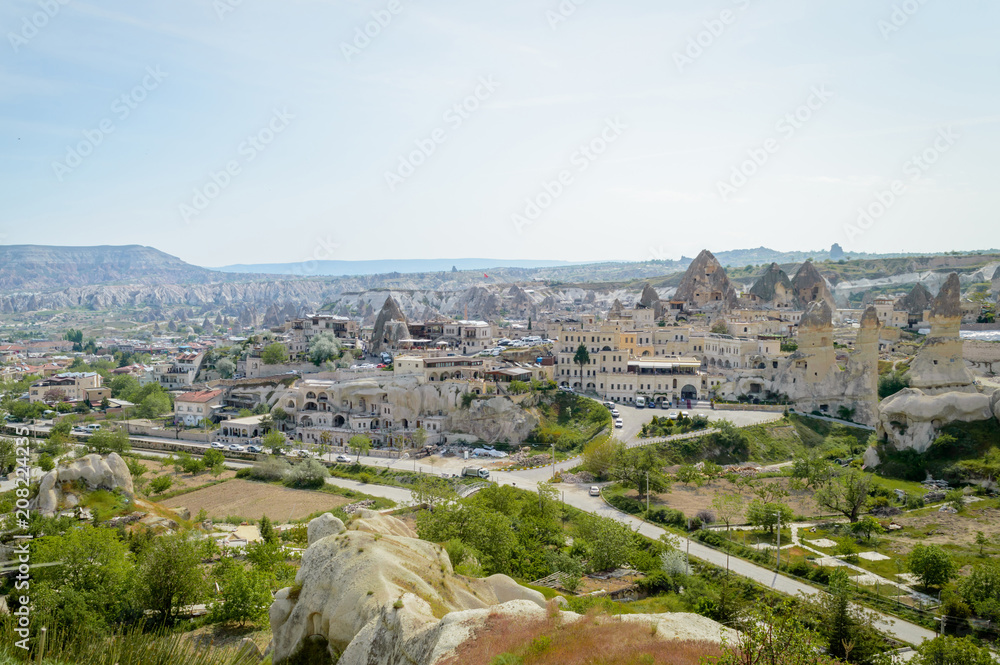 aerial view of cityscape and stone formations under cloudy blue sky, Cappadocia, Turkey