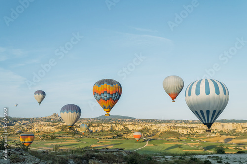 scenic view of colorful hot air balloons flying over valley of Cappadocia, Turkey