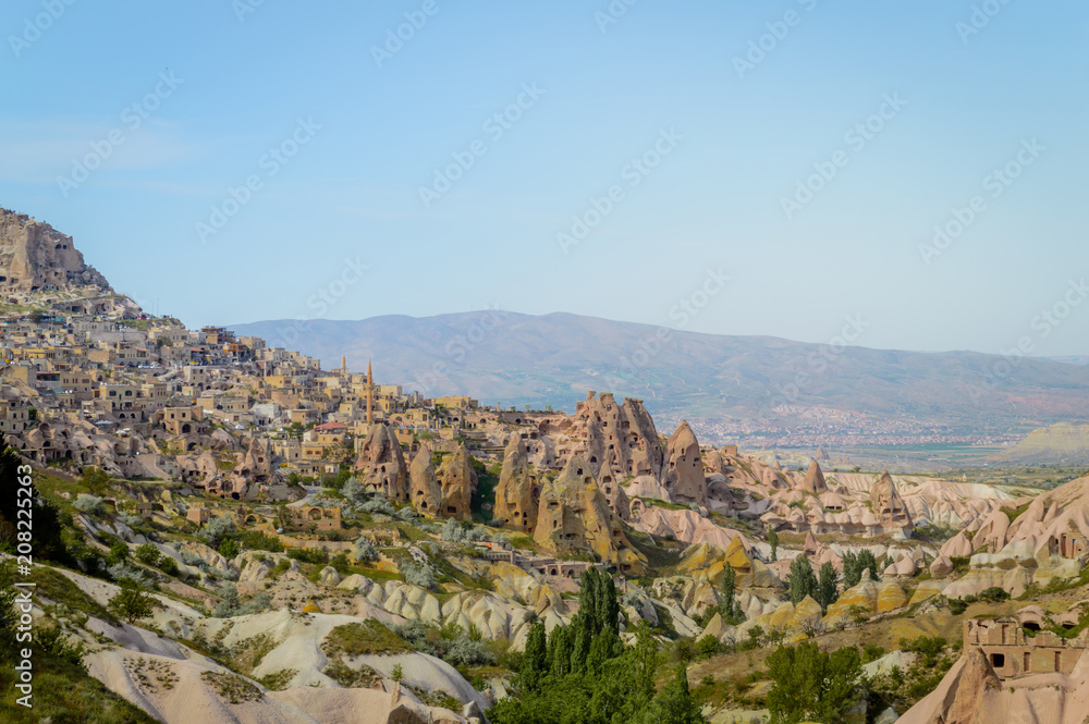 aerial view of cityscape and mountains under cloudless blue sky in Cappadocia, Turkey