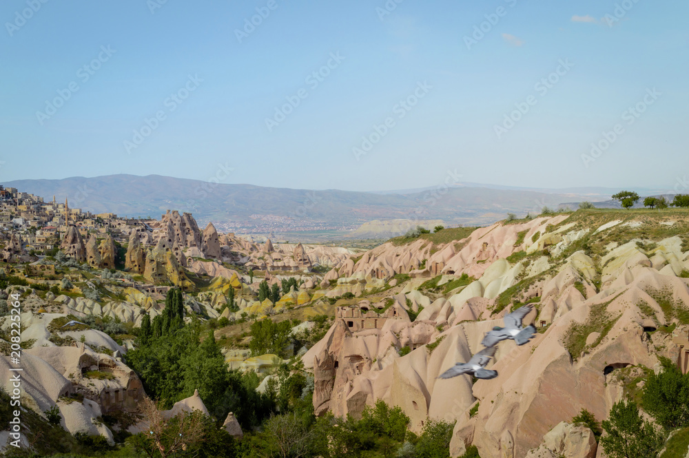 aerial view of mountains and cityscape under bright blue sky in Cappadocia, Turkey