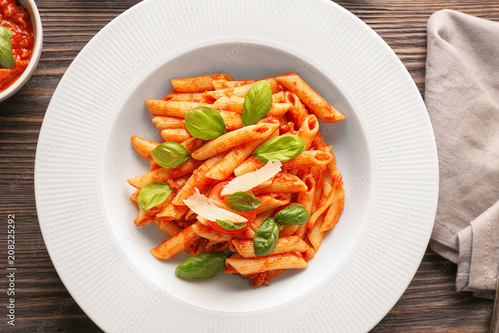 Plate of delicious pasta with tomato sauce on table Plate of delicious pasta with tomato sauce on table