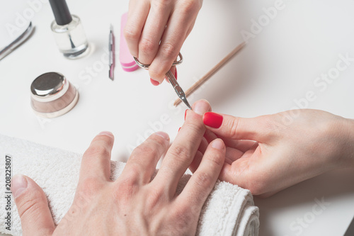 Men s manicure. hands of the technician cut the nails on men s hands