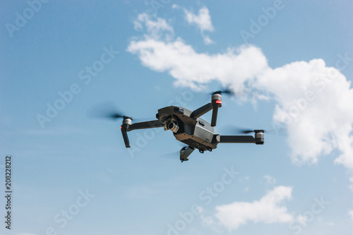 controlled modern drone flying in blue sky