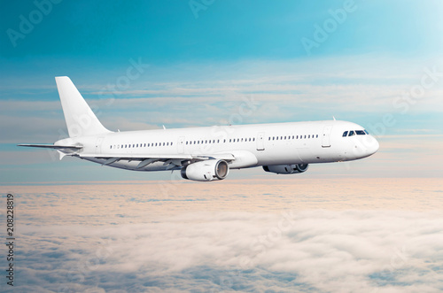 White airplane flies height  flight level high in the sky above the clouds blue sky.