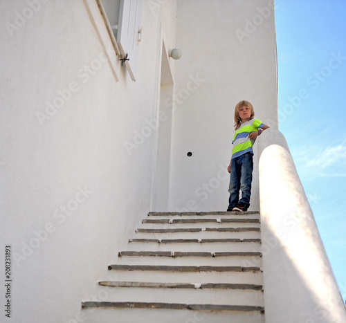 Portrait of little boy standing outside the house © Julia