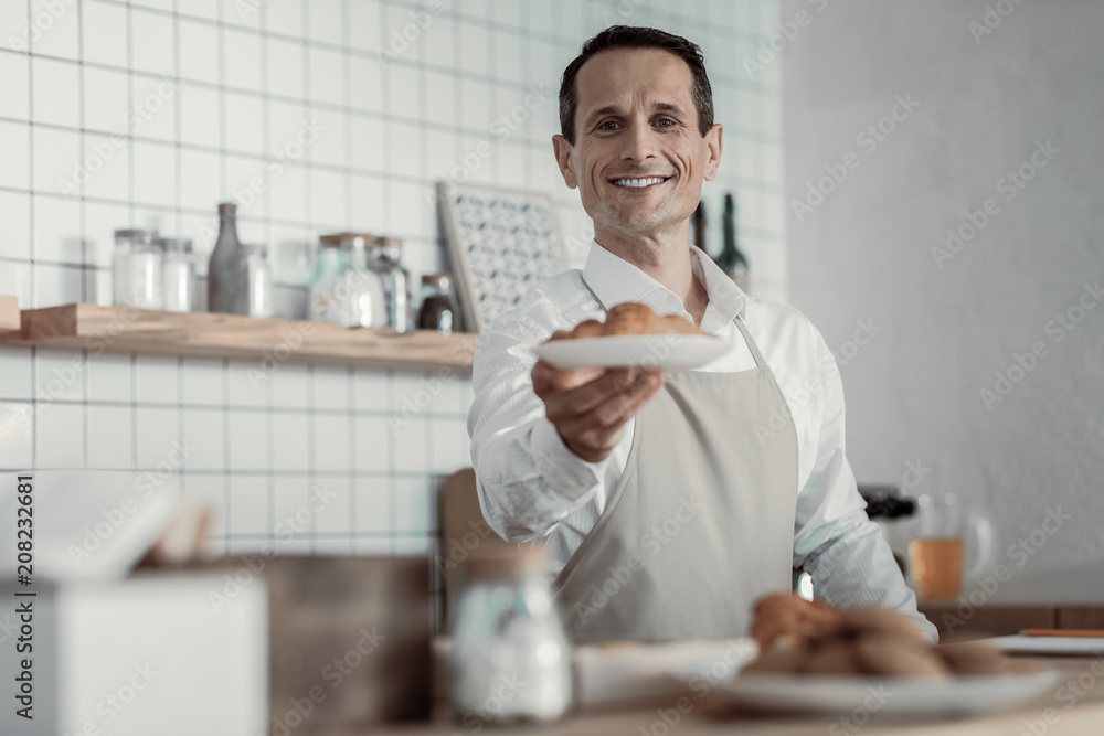 Enjoy your meal. Joyful waiter keeping smile on his face while posing on camera Enjoy your meal. Joyful waiter keeping smile on his face while posing on camera
