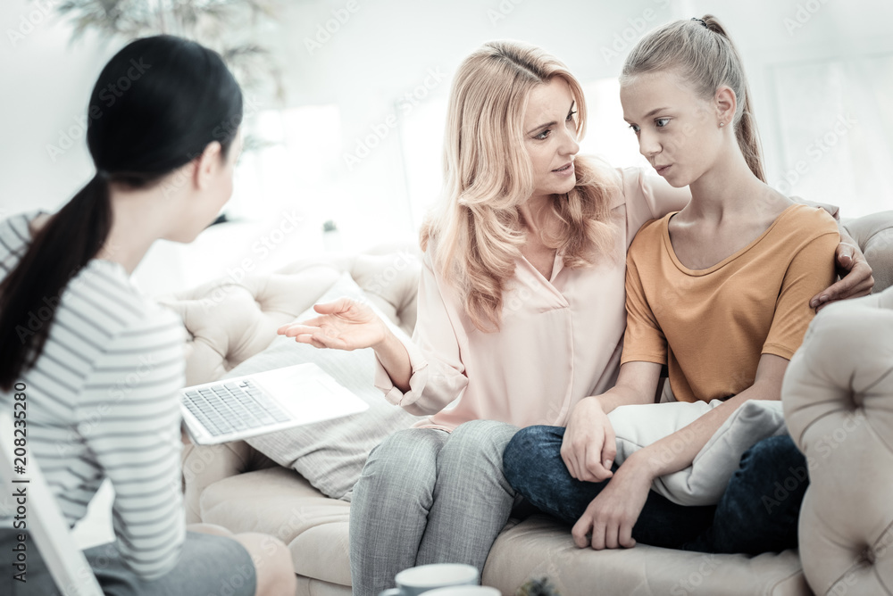 Family problems. Female psychologist holding laptop while appealing mother and daughter talking Family problems. Female psychologist holding laptop while appealing mother and daughter talking