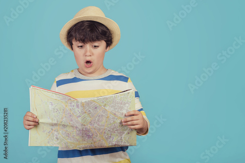 niño con sombrero y mapa sobre fondo azul