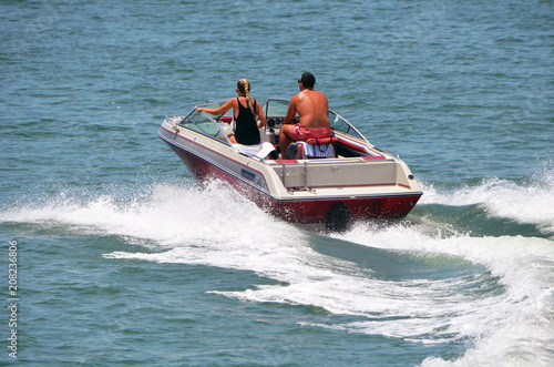 Young couple in a high end runabout motor boat speeding on the florida intra-coastal waterway off Miami Beach. © Wimbledon