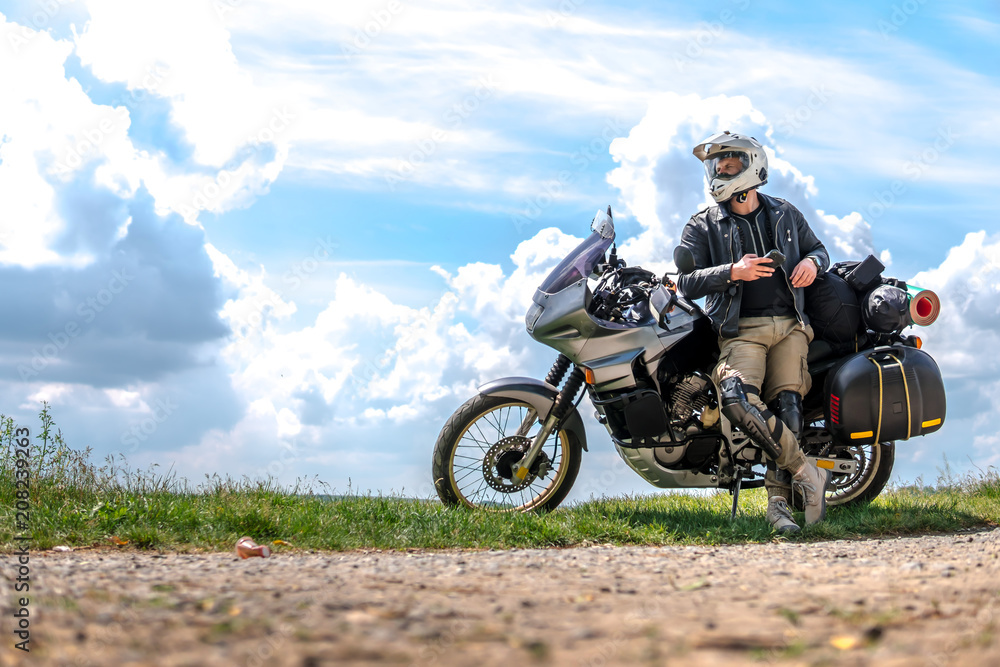 Rider Man and off road adventure motorcycles with side bags and equipment  for long road trip, river and clouds on background, enduro travel touring  concept Stock Photo | Adobe Stock