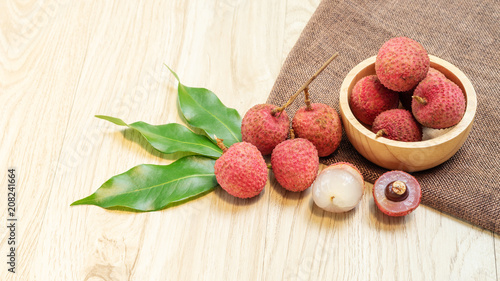 Red lychee fruit on a wooden table.