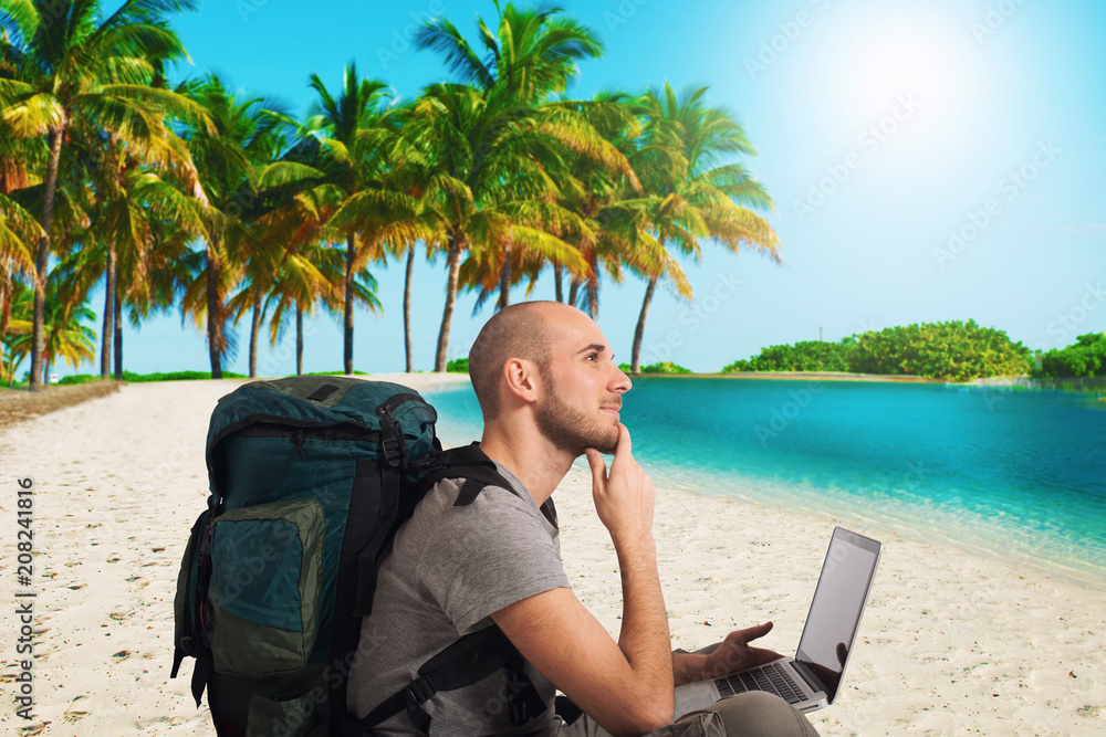 Explorer plans a new travel to a tropical beach with his laptop