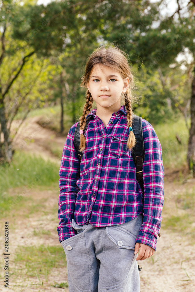 Little girl with backpack traveling in the forest Little girl with backpack traveling in the forest