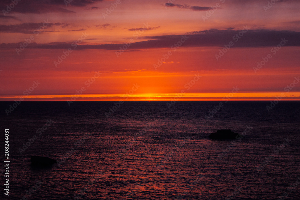Fototapeta premium background with red sunset over the sea, Etretat, Normandy, France