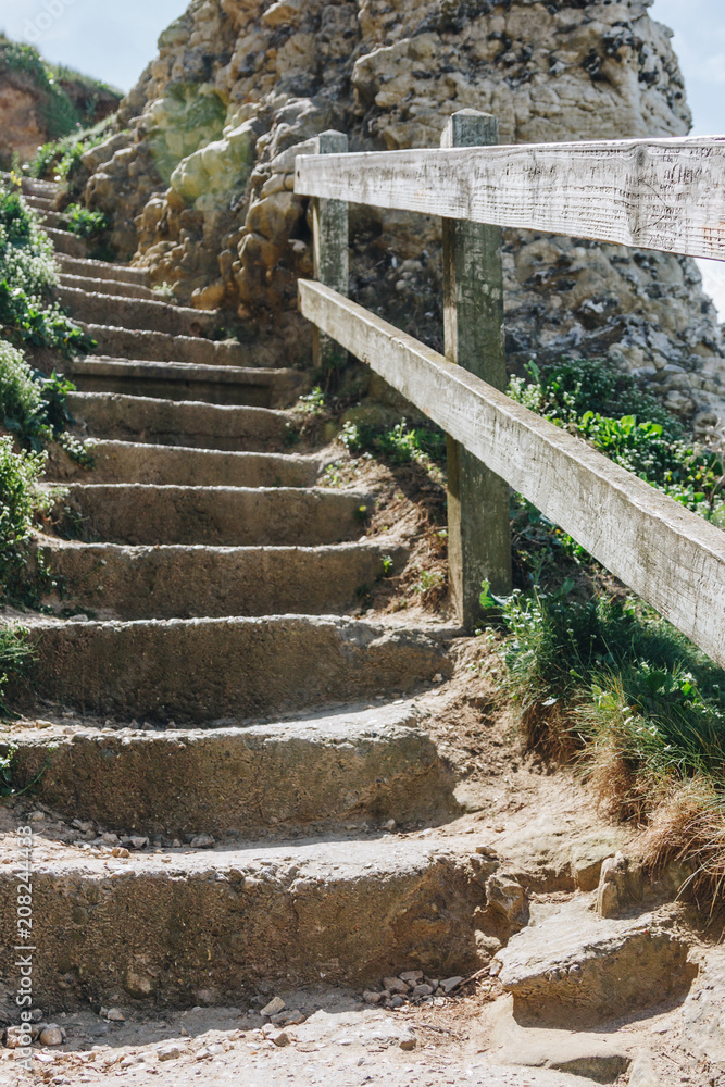 wooden railing and stone stairs on cliff, Etretat, Normandy, France