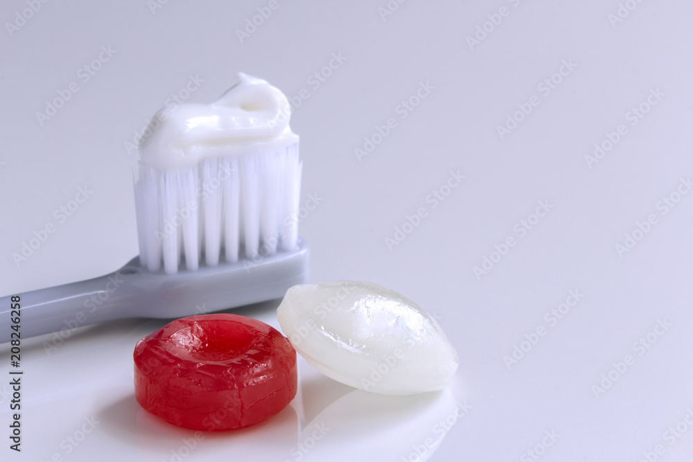 Toothbrush and candy on the white table. Toothbrush and candy on the white table.