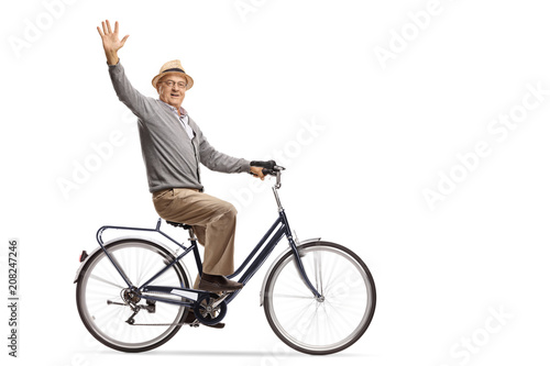 Mature man riding a bicycle and waving at the camera
