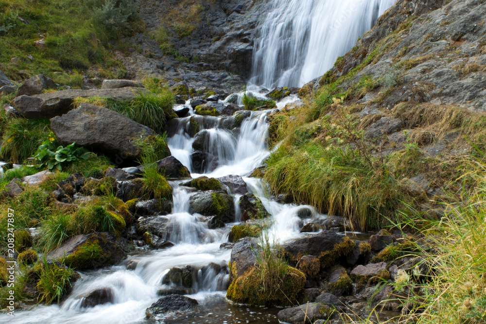 long exposure photo of wild river with a waterfall and grassy green surroundings long exposure photo of wild river with a waterfall and grassy green surroundings