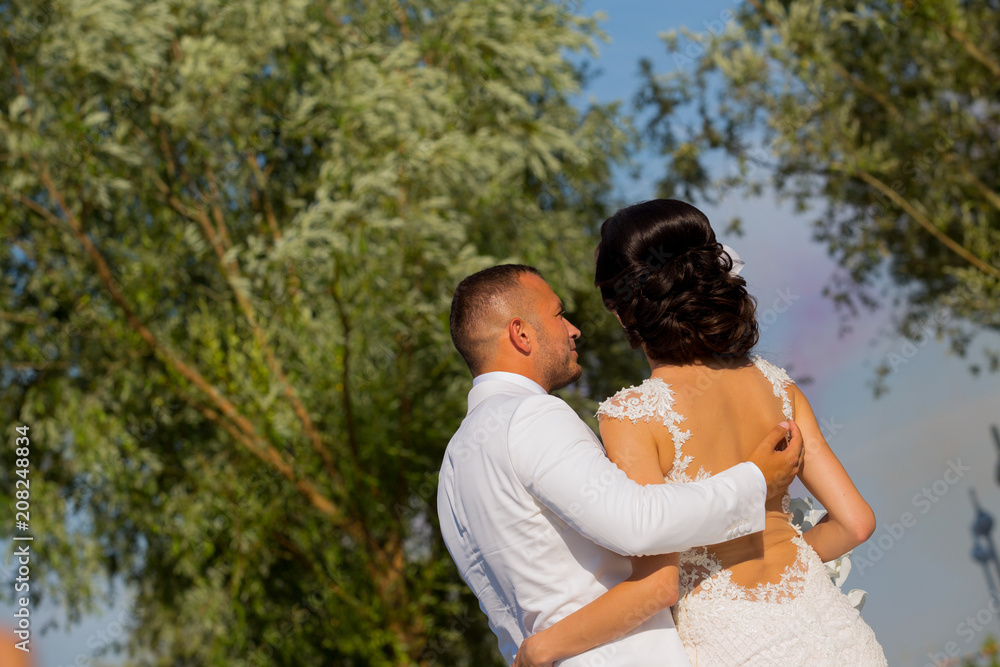 Beautiful Romantic Wedding Couple Of Newlyweds Hugging In Park On Sunset Beautiful Romantic Wedding Couple Of Newlyweds Hugging In Park On Sunset