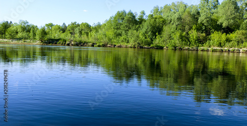 summer landscape. serene nature-green forest, clean river and a small beach.